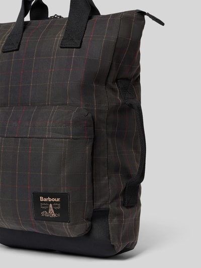 Produktfoto, Rucksack aus reiner gewachster Baumwolle von Barbour mit kariertem Muster in dunklen Farbtönen und sichtbarem Label. Herren Rucksack von Barbour