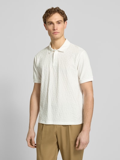 Männermodel trägt Regular Fit Poloshirt mit Strukturmuster von ARMANI EXCHANGE aus reiner Baumwolle, weiß, Knopfleiste, Ganzkörperansicht von vorne
