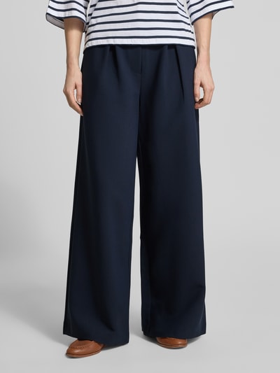 Frauenmodel trägt Wide Leg Hose Modell DORINA von GUIDO MARIA KRETSCHMER WOMAN in Dunkelblau mit Gelegte Falten, Material-Mix mit Viskose-Anteil, Ganzkörperansicht von vorne.