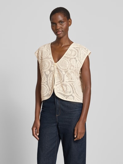Frauenmodel trägt Strickweste mit V-Ausschnitt Modell 'Crossy' von FREE/QUENT, Reine Baumwolle, Straight Fit, Beige, Strukturmuster, Ganzkörperansicht von vorne.