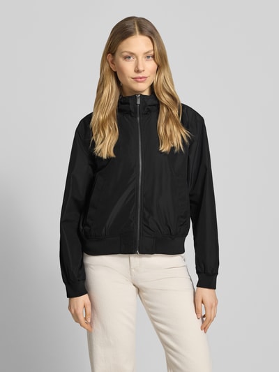 Frauenmodel trägt Regular Fit Blouson mit Kapuze von Tom Tailor Denim, Optik: Unifarben, Reißverschluss, Langarm, Funktion: wasserabweisend, wasserdicht, atmungsaktiv, seitliche Eingrifftaschen, Ganzkörperansicht von vorne.