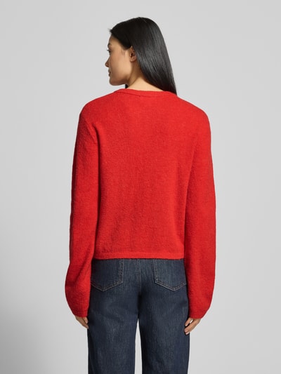Frauenmodel trägt rote Strickjacke mit Knopfleiste Modell 'Hanni' von GUIDO MARIA KRETSCHMER WOMAN, lockerer Schnitt, Rückansicht.