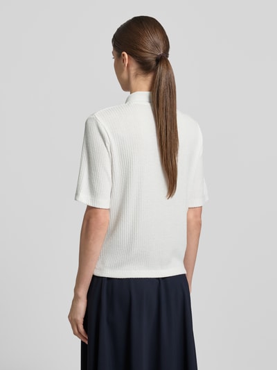 Frauenmodel trägt Regular Fit Poloshirt mit durchgehender Knopfleiste von OPUS, Viskose-Mix mit Stretch-Anteil, Farbmix Weiß und Dunkelblau, Struktur wirkt weich und leicht gerippt, Rückenlänge bei Größe 36: 54 cm, Ganzkörperansicht Rückansicht.