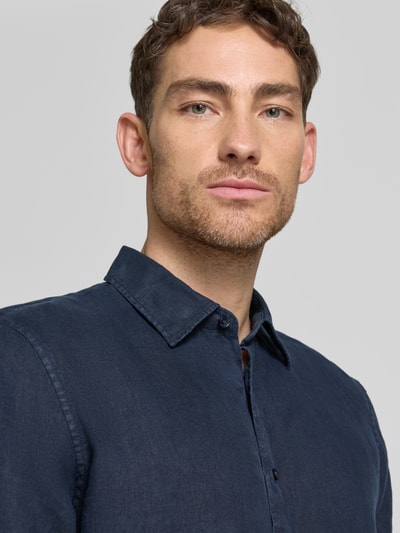 Männermodel trägt Leinenhemd mit Kentkragen von MCNEAL in Dunkelblau, Reine Leinen, Regular-Fit, Nahaufnahme Oberkörper.