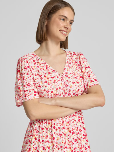 Frauenmodel trägt A-Linien Midikleid aus reiner Viskose Modell 'TALA' von Pieces mit Allover-Muster und V-Ausschnitt, Nahaufnahme Oberkörper.