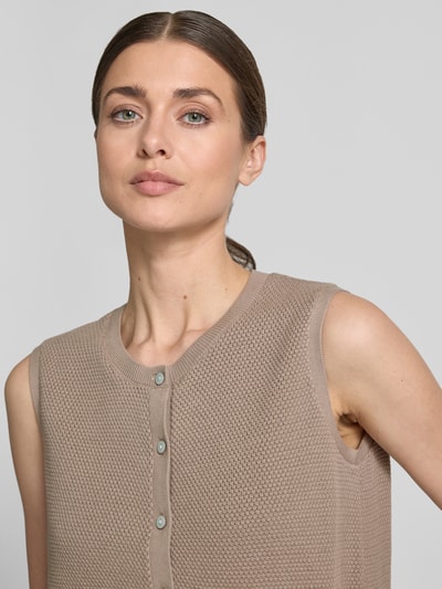 Frauenmodel trägt Weste mit Strukturmuster von Christian Berg Woman in Beige, Baumwolle, Rundhalsausschnitt, Knopfleiste, Nahaufnahme Oberkörper.