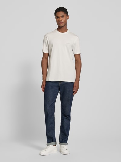 Männermodel trägt Extra Slim Fit T-Shirt mit Rundhalsausschnitt von Armani Exchange in Weiß mit Logo, Rückenlänge 70 cm bei Größe M, Ganzkörperansicht von vorne.
