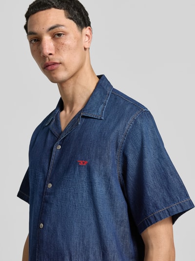 Männermodel trägt Regular Fit Jeanshemd aus Baumwolle von Diesel, durchgehende Druckknopfleiste, Reverskragen, Halbarm, Nahaufnahme Oberkörper