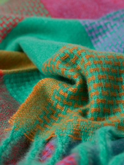 Produktfoto, Schal mit Fransen Modell 'happy' von Kurt Beines in Grün mit orangefarbenen Details, Strick-Optik, weiche Textur