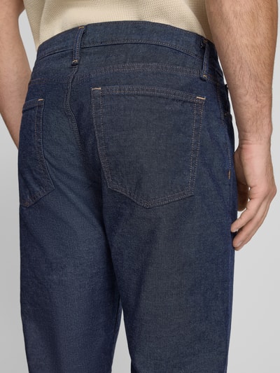 Männermodel trägt Relaxed Straight Fit Jeans mit Eingrifftaschen von GAP aus reiner Baumwolle in dunklem Blau, Detailaufnahme Rückansicht.