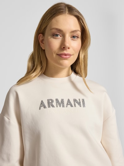 Frauenmodel trägt Sweatshirt mit Logo-Print und Rundhalsausschnitt von ARMANI EXCHANGE aus Baumwoll-Mix mit Stretch-Anteil, Loose-Fit, Nahaufnahme Oberkörper.