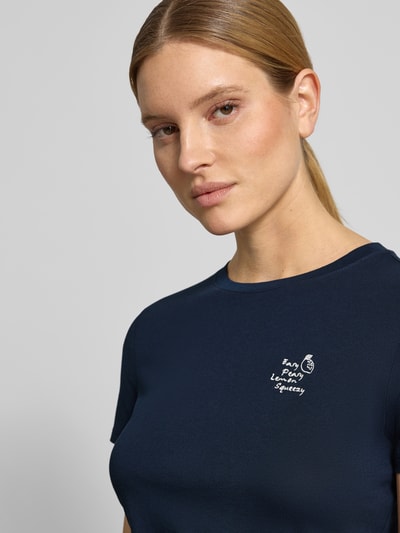 Frauenmodel trägt Regular Fit T-Shirt aus reiner Baumwolle von Tom Tailor Denim in Dunkelblau, unifarbenes Jersey mit Statement-Stitching, Nahaufnahme Oberkörper.