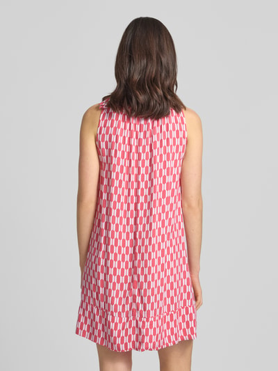 Frauenmodel trägt Knielanges Kleid aus Viskose mit Rundhalsausschnitt von ZABAIONE, lockerer Schnitt, rosa mit weißem Muster, Rückansicht, Ganzkörperansicht.