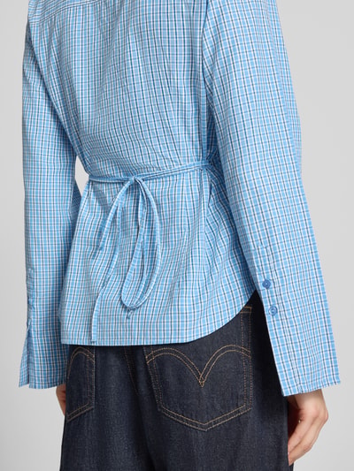 Vrouwenmodel draagt Regular Fit blouse met strikceintuur model 'CARO' van JJXX, materiaalmix met katoen, ruglengte maat S 64 cm, mouwlengte 64 cm, ruitjesmotief, detailopname rugaanzicht.