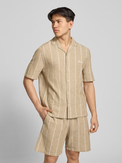 Männermodel trägt Regular Fit Freizeithemd aus Baumwoll-Leinen-Mix mit Reverskragen von REVIEW, sandfarben mit weißen Streifen, Nahaufnahme Oberkörper.