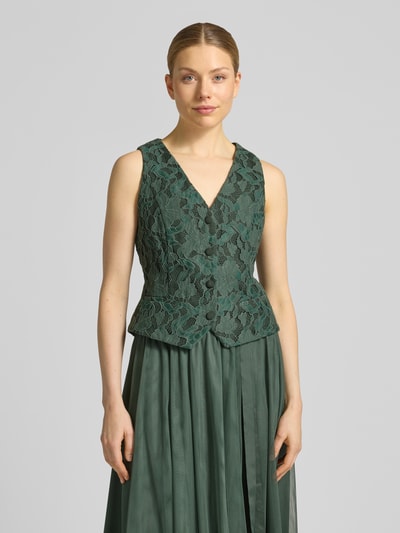 Modelka nosi Regular Fit Weste mit Spitzenbesatz od V by Vera Mont, zielony materiał mix z bawełną, koronkowe detale, krój regular fit, V-dekolt, taliowana, długość tyłu w rozmiarze 36: 51 cm, widok całej sylwetki z przodu