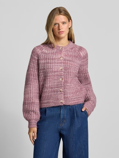 Frauenmodel trägt Cardigan mit Woll-Anteil und Rundhalsausschnitt von REVIEW, Material-Mix, gerade geschnitten, Strukturstrick in Rosa, Ganzkörperansicht von vorne.