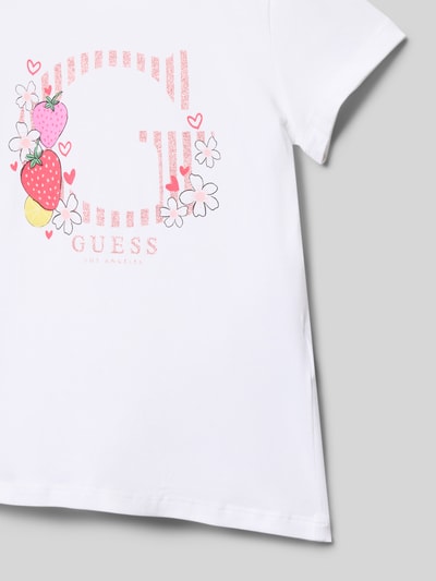 Mädchen trägt T-Shirt mit Rundhalsausschnitt und Motiv-Print von Guess aus Baumwoll-Mix mit Stretch-Anteil, Gerader-Schnitt, Nahaufnahme Oberkörper.
