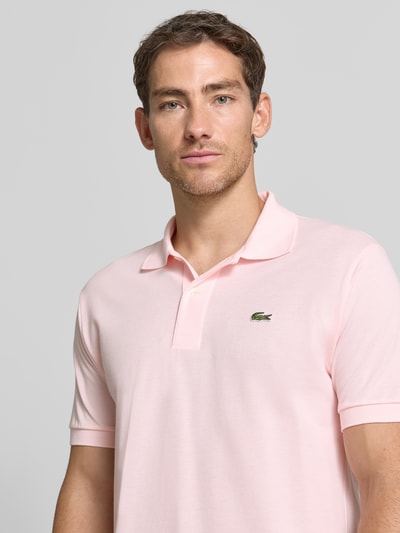 Männermodel trägt Regular Fit Poloshirt aus reiner Baumwolle von Lacoste in Hellrosa, glatte Struktur, Nahaufnahme Oberkörper, Herren Poloshirt von Lacoste