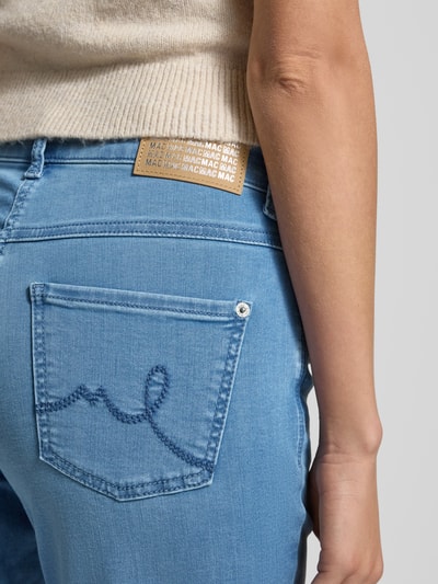 Kobieta nosi Jeans mit 5-Pocket-Design Modell 'Laura' od MAC z bawełnianej mieszanki, jasnoniebieski kolor, detal tylnej kieszeni, szerokość w rozmiarze 36/32: 38 cm, długość wewnętrzna nogawki: 80 cm, zapięcie na guzik i zamek, prosty krój, zbliżenie na biodra