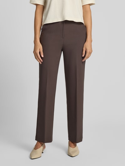 Frauenmodel trägt Straight Fit Hose mit Viskose-Anteil von COMMA, braun, elastischer Stoff, Bügelfalten, Nahaufnahme Unterkörper, Ganzkörperansicht von vorne.