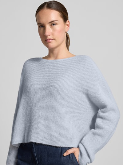 Frauenmodel trägt Oversized Wollpullover aus Alpaka-Mix von DRYKORN in Hellblau, Ripp-Optik, Rundhalsausschnitt, Nahaufnahme Oberkörper.