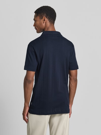 Männermodel trägt Regular Fit Poloshirt in Jaquard-Strick von Lindbergh in Dunkelblau aus Reine Baumwolle, Rückenlänge 73 cm, Ganzkörperansicht Rückansicht.