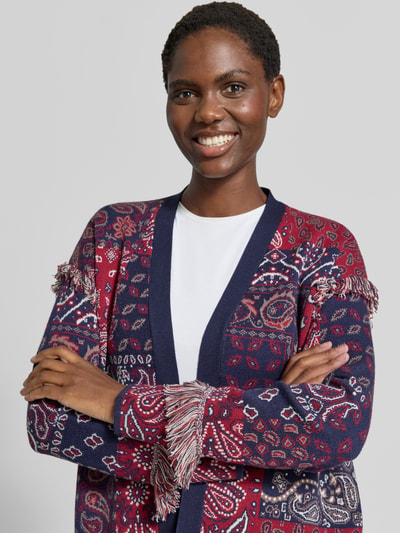 Vrouwenmodel draagt Cardigan aus Viskose-Mix in Strick-Optik van Christian Berg Woman, Viscosemix, los model, tricotlook, all-over paisleyprint, ruglengte maat S: 66 cm, mouwlengte maat S: 60 cm, rijk aan rood en donkerblauw, geometrische en paisley vormen, zachte textuur, Nahaufnahme Oberkörper.