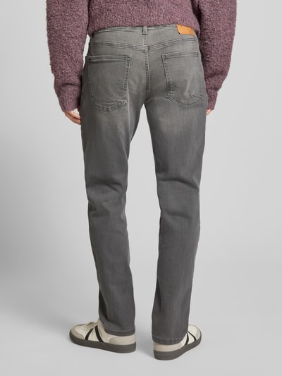 Männermodel trägt Bequeme Slim Fit Jeans in grauer Waschung und Five-Pocket-Design von REVIEW aus Baumwoll-Mix, Ganzkörperansicht Rückansicht.