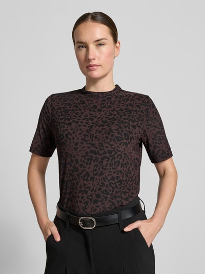 Frauenmodel trägt T-Shirt mit Leo-Print von MORE & MORE, braun-schwarze Muster, gerader Schnitt, Nahaufnahme Oberkörper, Material-Mix mit Stretch-Anteil, Stehkragen, Rückenlänge bei Größe 36: 54 cm.
