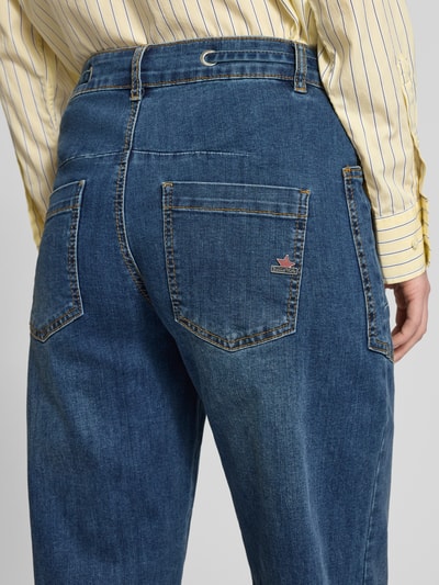 Frauenmodel trägt Barrel Fit Jeans mit Viskose-Anteil Modell 'Barrel' von Buena Vista, blaue Baumwoll-Mix-Jeans mit aufgesetzten Taschen und Tunnelzug, Nahaufnahme Rückansicht, Bundweite bei Größe S 40 cm, Innenbeinlänge 68 cm.
