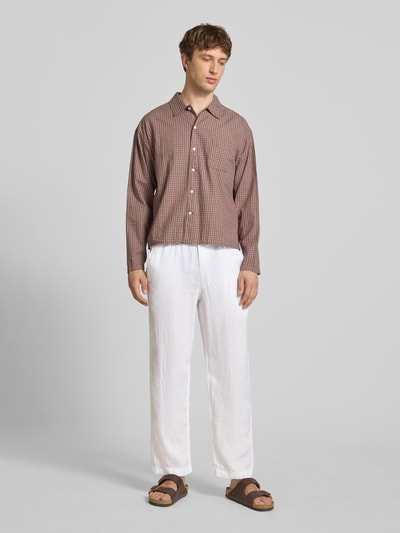 Männermodel trägt Leinenhose mit Eingrifftaschen Modell 'KARL LAWRENCE' von Jack & Jones Premium in Weiß, Ganzkörperansicht von vorne. Herren, Reines Leinen, Straight Fit, Elastischer Bund, Knopf- und Reißverschluss, Französische Eingrifftaschen, Gesäßleistentaschen, Bundweite bei Größe M 42 cm, Innenbeinlänge bei Größe M 75 cm.