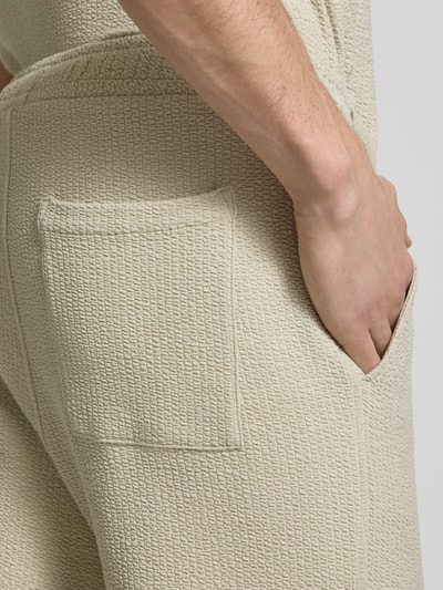 Männermodel trägt Straight Fit Sweatpants mit elastischem Bund von JAKE*S STUDIO MEN, cremefarben mit Strukturmuster, Detailaufnahme Hüfte.
