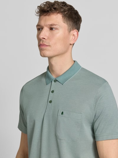 Männermodel trägt Regular Fit Poloshirt mit Knopfleiste und Brusttasche von RAGMAN, Baumwoll-Mix in Grün, Nahaufnahme Oberkörper.