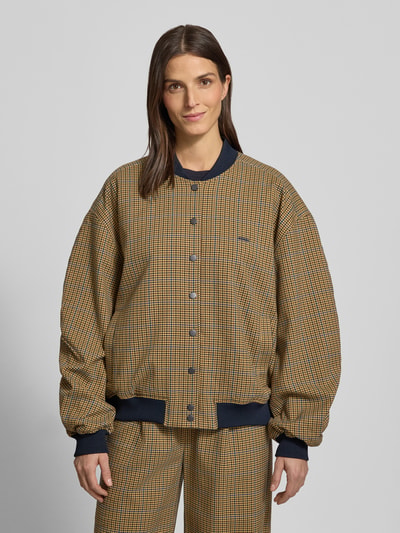 Frauenmodel trägt Loose Fit Bomberjacke mit Knopfleiste Modell 'chicca' von Gestuz, Karomuster, Stehkragen, Ganzkörperansicht von vorne.