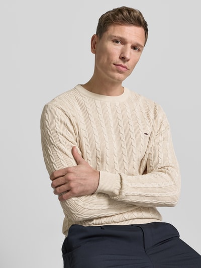 Männermodel trägt Strickpullover mit Zopfmuster und Label-Stitching von Fynch-Hatton, Slim-Fit, reine Baumwolle, Rundhalsausschnitt, Nahaufnahme Oberkörper.