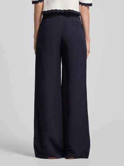 Frauenmodel trägt Wide Fit Stoffhose aus Viskose-Mix mit Leinen-Anteil von Marc Cain in Dunkelblau, mit Paspeltaschen und Logo-Detail, Ganzkörperansicht Rückansicht. Damen Stoffhose mit Eingrifftaschen, Bundweite bei Größe 36: 37 cm, Innenbeinlänge bei Größe 36: 82 cm.