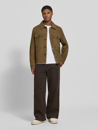 Męski model nosi brązową kurtkę skórzaną Regular Fit Lederjacke aus echtem Ziegenleder Modell 'THOM' von Selected, prosta faktura, przód, kontekst: Herren Leder- / Kunstlederjacke von Selected, zdjęcie całej sylwetki z przodu.