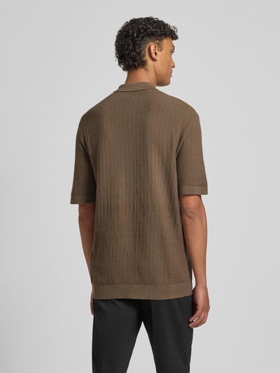 Männermodel trägt Regular Fit Poloshirt aus reiner Bio-Baumwolle Modell 'CRAN' von SELECTED HOMME in Strickoptik mit Struktur-Muster, Ganzkörperansicht Rückansicht.