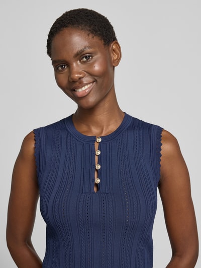 Frauenmodel trägt Stricktop in Pointelle-Strick mit kurzer Knopfleiste von GUESS, navyblau, Viskose-Mix, Nahaufnahme Oberkörper.