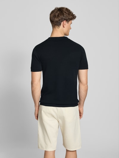 Männermodel trägt Regular Fit Poloshirt in Strick-Optik Modell 'Bray' von Blend, Reine Baumwolle, Schwarz, Kurzärmelig, Rückenlänge 68 cm, Ganzkörperansicht Rückansicht.