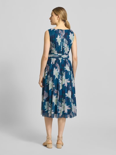Frauenmodel trägt Cocktailkleid mit Taillenband von Christian Berg Cocktail in Blau mit floralen Mustern aus Elastischer-Material-Mix und Raffungen, Taillierte Passform, Midikleid, Rundhalsausschnitt, Reißverschluss auf der Rückseite, Rückenlänge bei Größe 36: 123 cm, Brustweite bei Größe 36: 44 cm, Ganzkörperansicht Rückansicht.