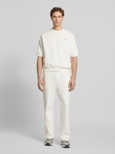 Männermodel trägt Loose Fit Sweatpants aus reiner Baumwolle von Lacoste in Optik: Unifarben, Logo-Detail, Sweat, Ganzkörperansicht von vorne.