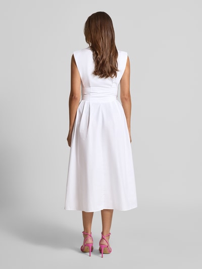 Modelka kobieca nosi białe Midikleid mit verdeckter Knopfleiste Modell 'CHERRY' od Guess z czystej bawełny, krój slim fit, długość do połowy łydki, marszczona talia, szerokość w rozmiarze S: 36 cm, długość pleców w rozmiarze S: 32 cm, widok całej sylwetki z tyłu.