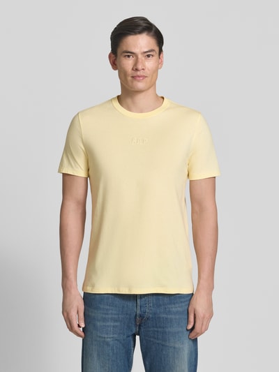 Männermodel trägt T-Shirt mit Rundhalsausschnitt und Label-Stitching von GAP, reine Baumwolle, Regular Fit, gelb, Ganzkörperansicht von vorne