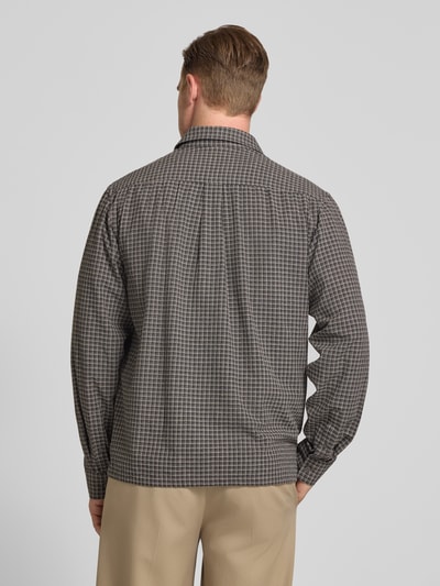 Męski model nosi Regular Fit Freizeithemd mit Kentkragen Modell 'Nico' od Wood Wood, bawełna z domieszką wiskozy, wzór w kratę, brąz i szarość, krój regular fit, kieszenie na piersi, długość tyłu w rozmiarze M: 72 cm, szerokość ramion w rozmiarze M: 43 cm, długość rękawa w rozmiarze M: 67 cm, zdjęcie całej sylwetki z tyłu.