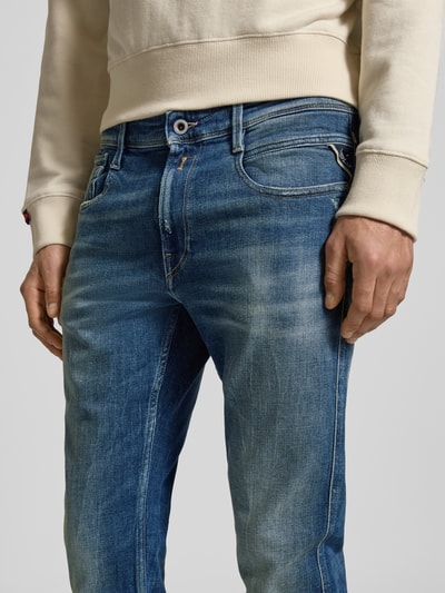 Männermodel trägt Slim Fit Jeans aus Baumwoll-Mix im Destroyed-Look von Replay, 5-Pocket-Design, Kontrastnähte, Nahaufnahme Oberkörper.
