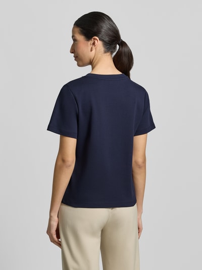 Modelka nosi T-shirt mit Perlen und Ziersteinbesatz od Christian Berg Woman, bawełna, krój regular fit, okrągły dekolt, długość tyłu 53 cm, widok z tyłu na całe ciało.