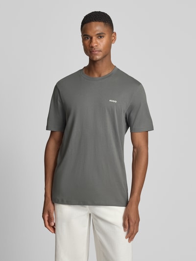 Männermodel trägt Regular Fit T-Shirt aus reiner Baumwolle Modell 'DERO222' von HUGO, Optik: Unifarben, Label-Print, Jersey, Ganzkörperansicht von vorne.