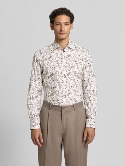 Männermodel trägt Body Fit Businesshemd aus Baumwoll-Mix von OLYMP Level 5 mit beigem Paisley-Muster, Ganzkörperansicht von vorne.